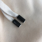 Stone Island shorts drawstring cord ends with Moncler print on cream fabric