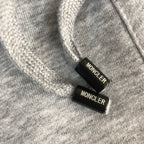 Moncler-branded drawstring cord ends on heather gray shorts waistband.