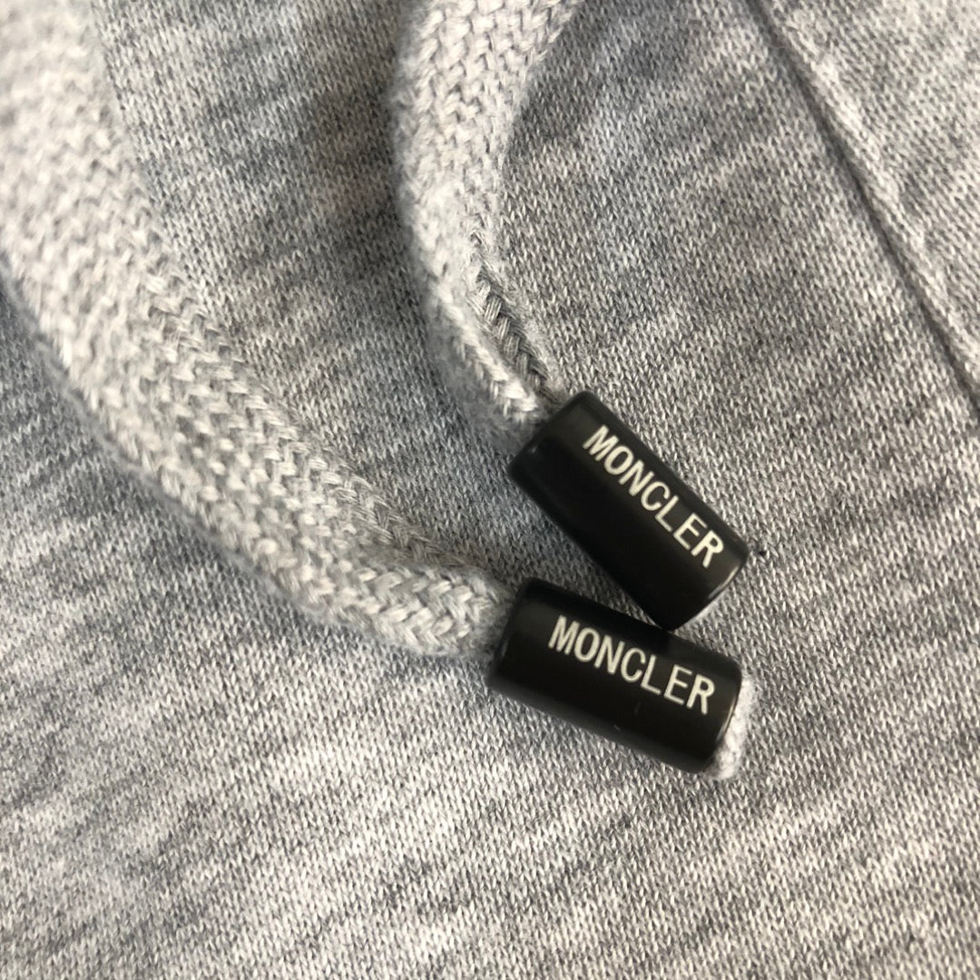 Moncler-branded drawstring cord ends on heather gray shorts waistband.