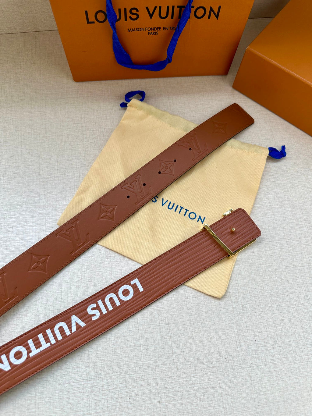 Louis Vuitton belt strap shown flat with brown embossing and silver-tone buckle