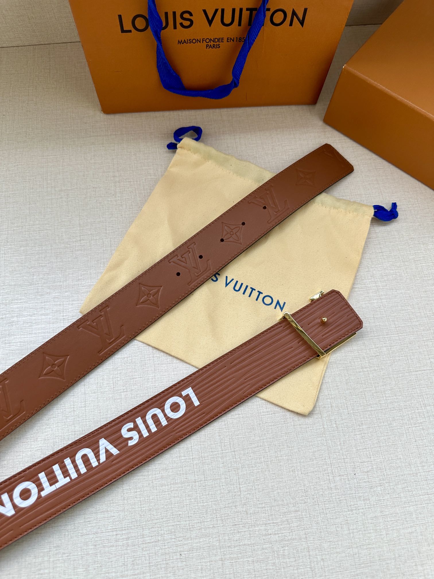 Louis Vuitton belt strap shown flat with brown embossing and silver-tone buckle