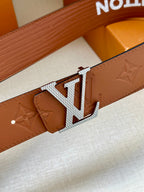 Louis Vuitton belt buckle close-up with silver-tone LV emblem on brown leather strap
