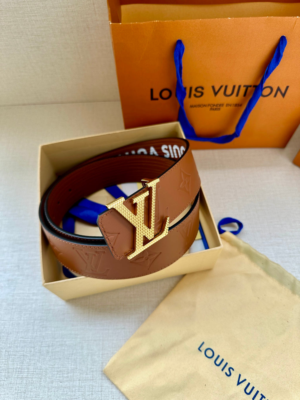 Louis Vuitton belt in open box with brown strap and gold-tone LV buckle
