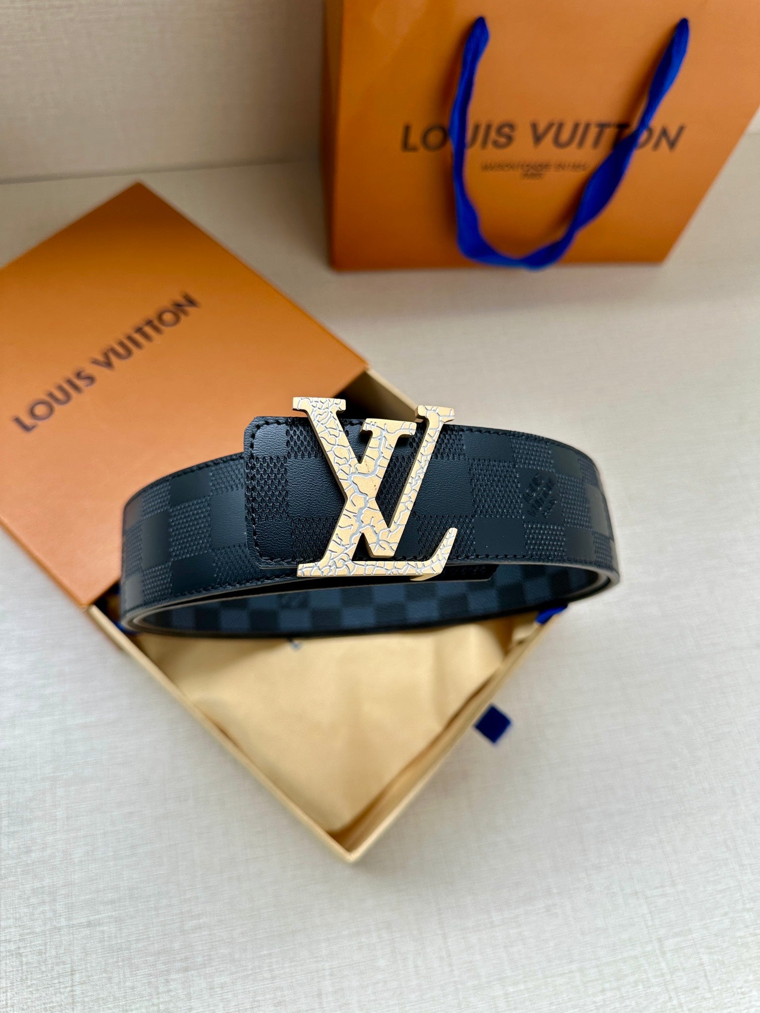 Louis Vuitton belt, dark blue checkered strap with prominent silver-tone LV buckle plate