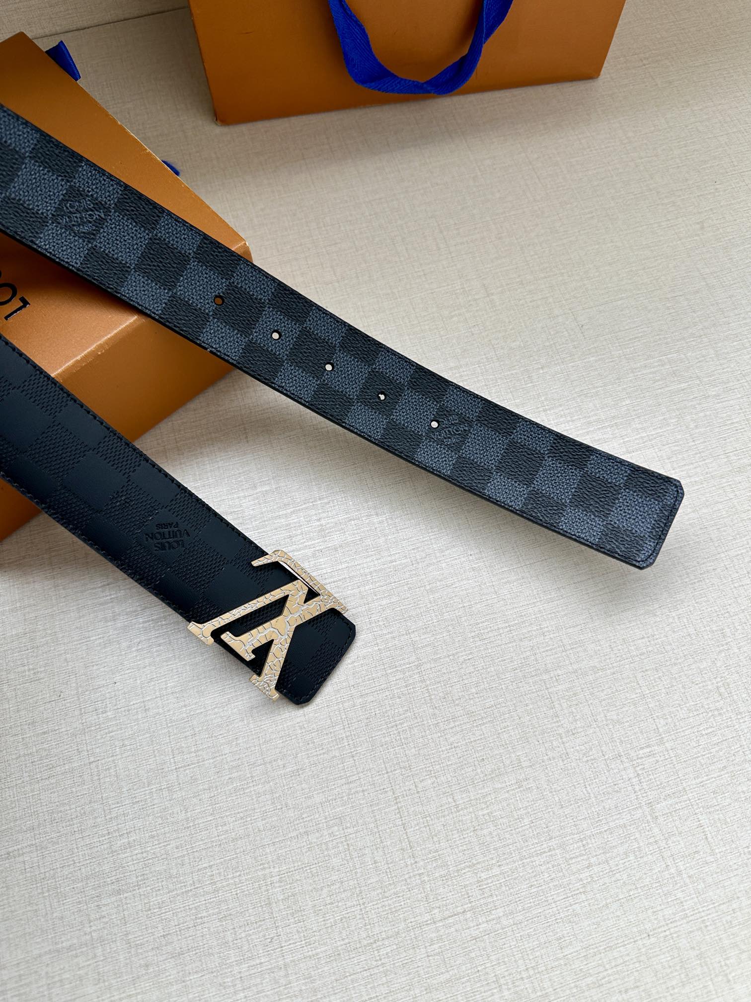 Louis Vuitton belt strap with dark blue checkered pattern and silver-tone LV buckle ends