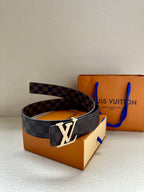 Louis Vuitton belt with dark checker strap and metallic LV buckle, angled view