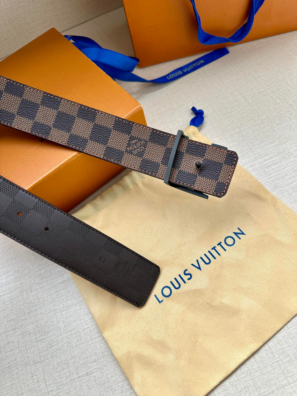 Louis Vuitton belt with dark checker strap and rectangular metallic buckle plate