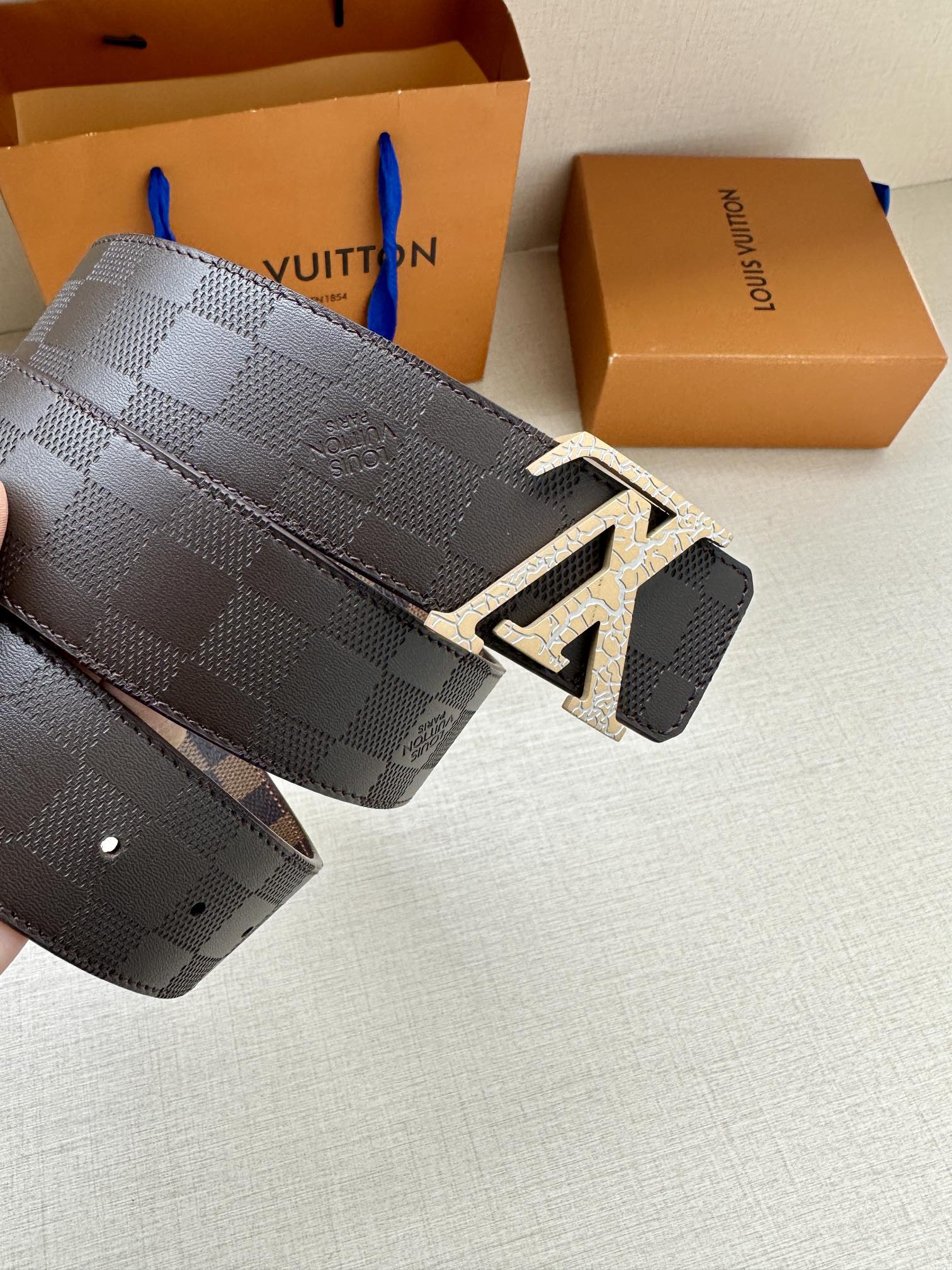 Louis Vuitton belt with dark checker strap and metallic LV buckle on end tab