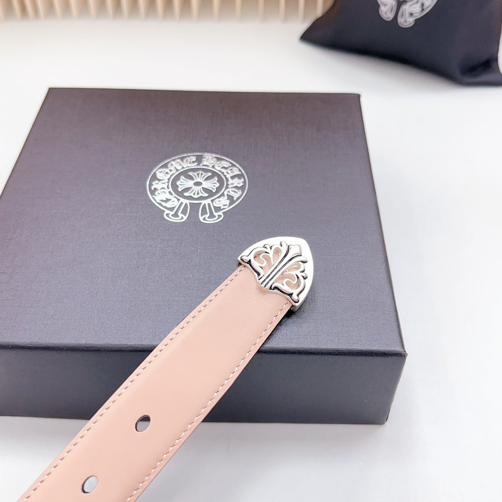 Tan leather belt close-up showing ornate silver-tone buckle plate and eyelets