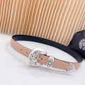 Leather belt with navy edge and ornate silver-tone buckle, tan strap with eyelets