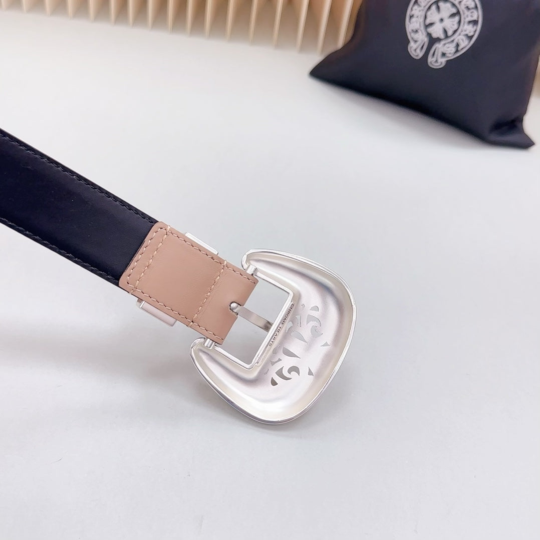 Navy-edged leather belt close-up with ornate silver-tone buckle and tan keeper