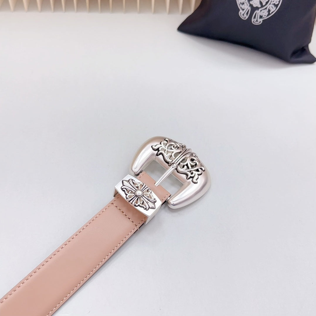 Tan leather belt close-up with ornate silver buckle and center metal keeper