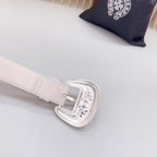 Beige leather belt with adjustable holes and silver-tone buckle with ornate engraving
