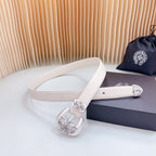 Beige leather belt with chrome buckle featuring carved floral and scrollwork