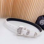 White leather belt with silver ornate buckle and keeper detail