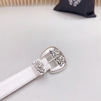 White leather belt with silver buckle featuring floral filigree