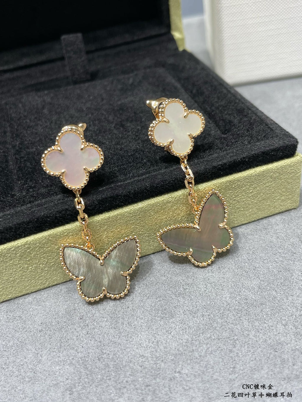 Butterfly drop earrings with white clover tops and pale green butterfly charms on chains