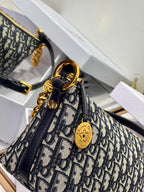 Dior monogram mini shoulder bag close-up with gold emblem charm and chain strap