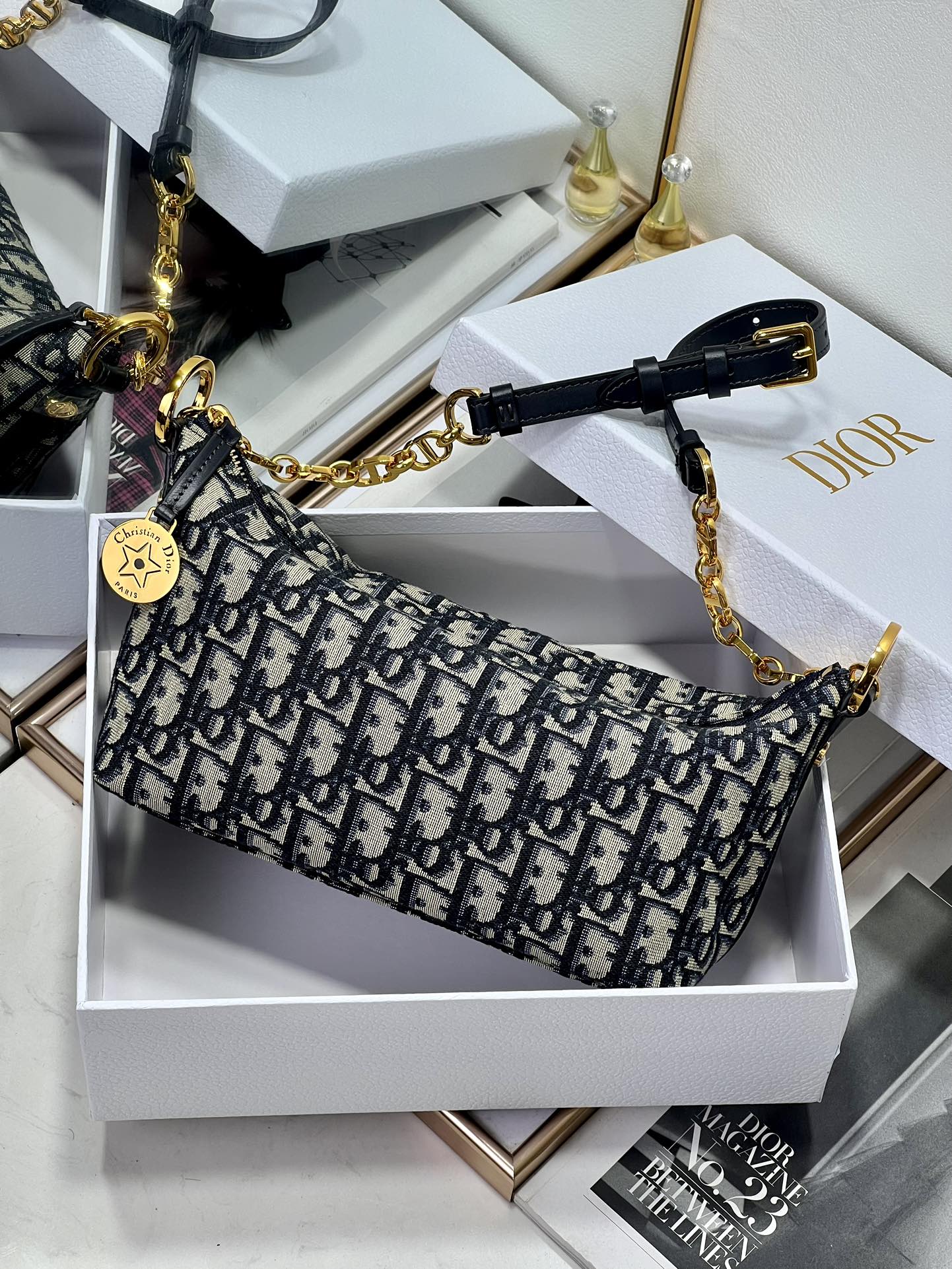 Dior small shoulder bag with blue monogram pattern, zip closure, and gold chain strap