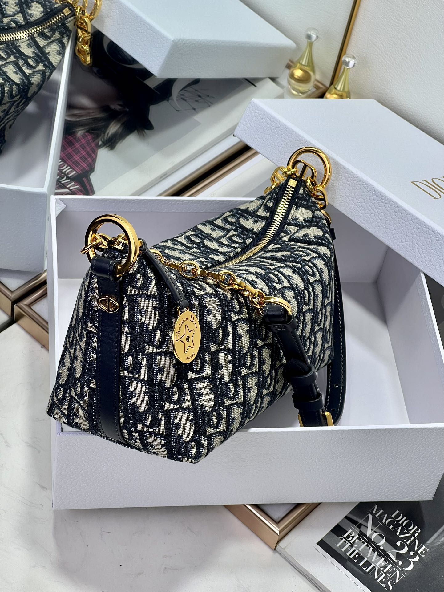 Dior mini satchel-style bag with blue monogram pattern, top handle, and gold hardware