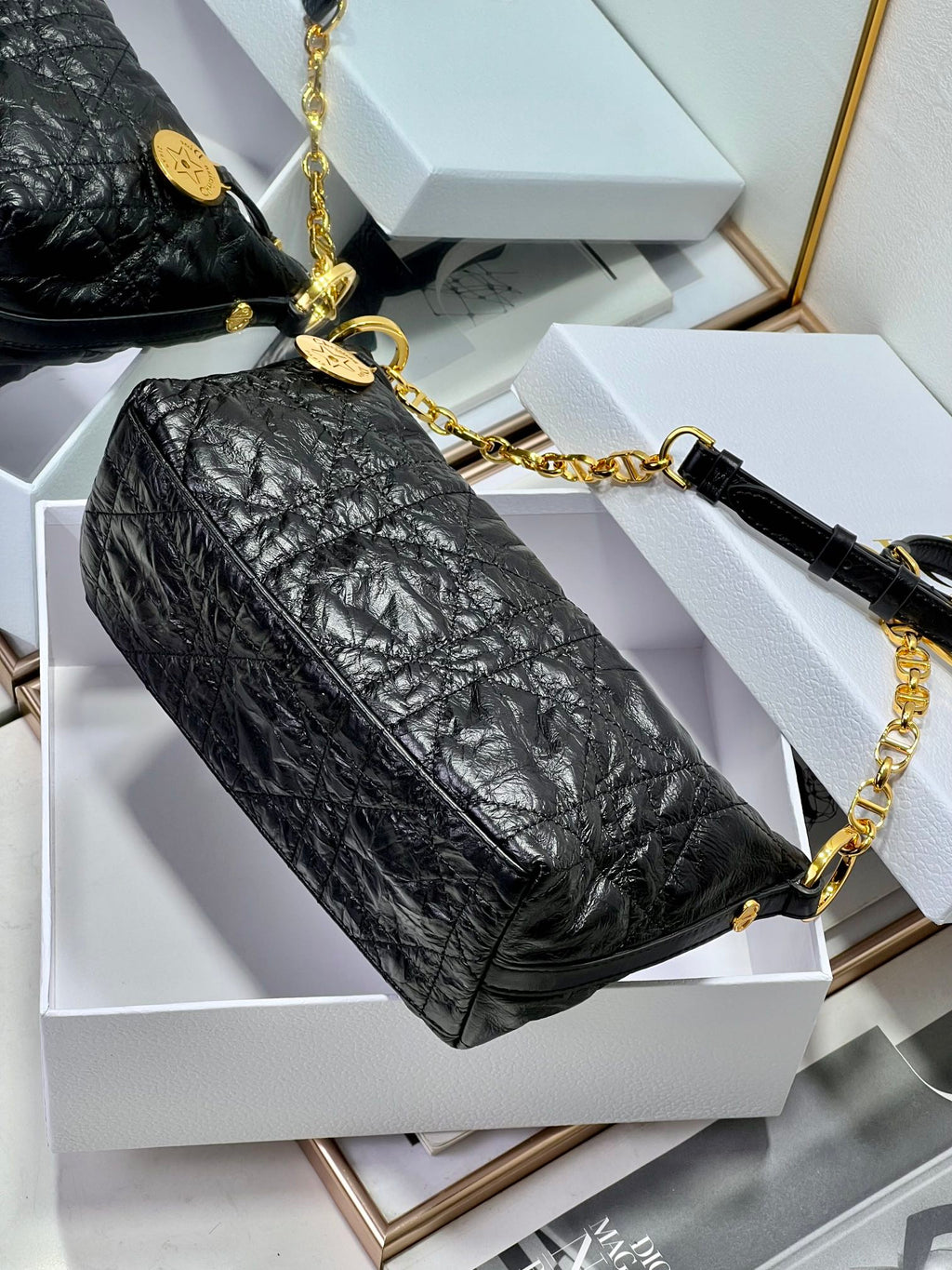 Dior black hobo bag with gold chain strap and gold-toned hardware.