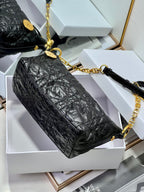 Dior black hobo bag with gold chain strap and gold-toned hardware.