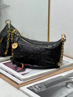 Dior black hobo bag with gold chain shoulder strap and zipper closure.