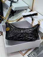 Dior black hobo bag with gold chain strap and zipper pocket detailing.