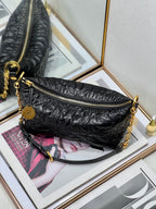 Dior black hobo bag with gold zipper, chain strap, and round logo charm.