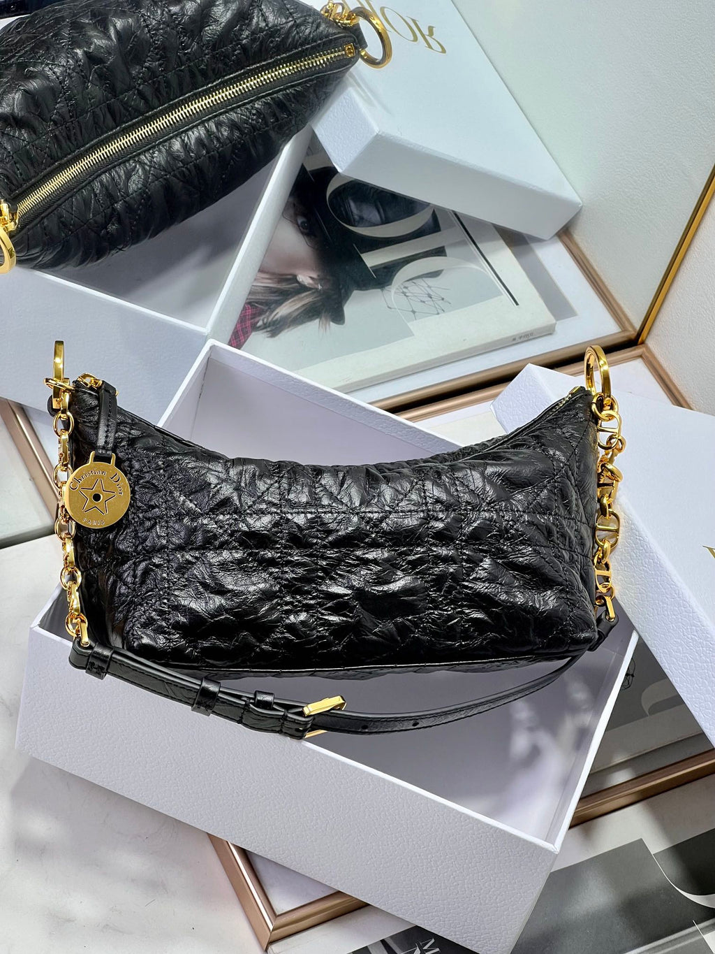 Dior black hobo bag with gold chain shoulder straps and zip closure.
