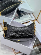 Dior black hobo bag with gold chain shoulder straps and zip closure.