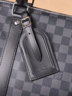Men's Louis Vuitton logo leather luggage tag on checkered duffel bag