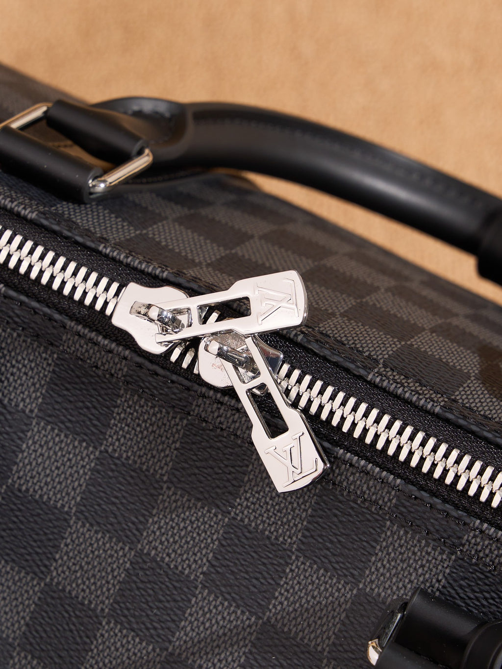 Men's Louis Vuitton checkered bag zipper pull with silver star-shaped detail