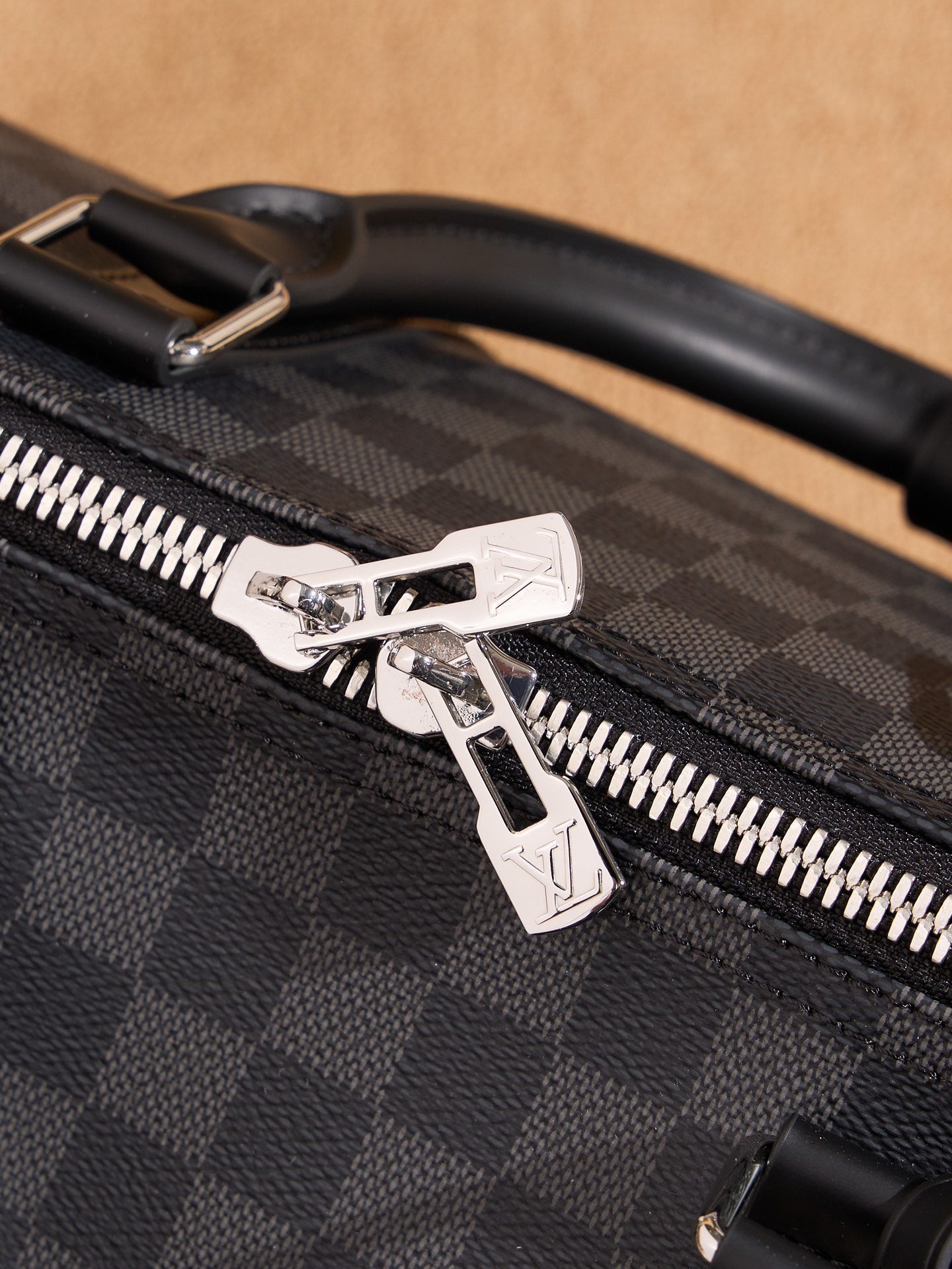 Men's Louis Vuitton checkered bag zipper pull with silver star-shaped detail