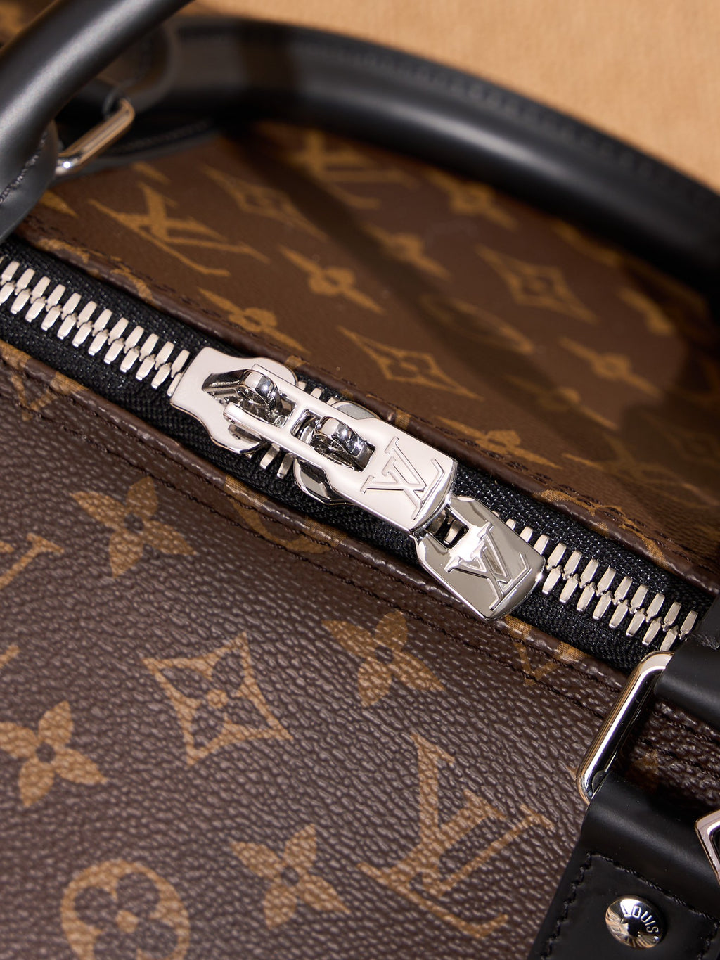 Zip pull and silver-toned metal trim on monogram duffel bag