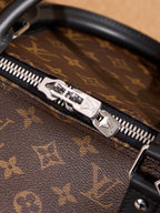 Zip pull and silver-toned metal trim on monogram duffel bag