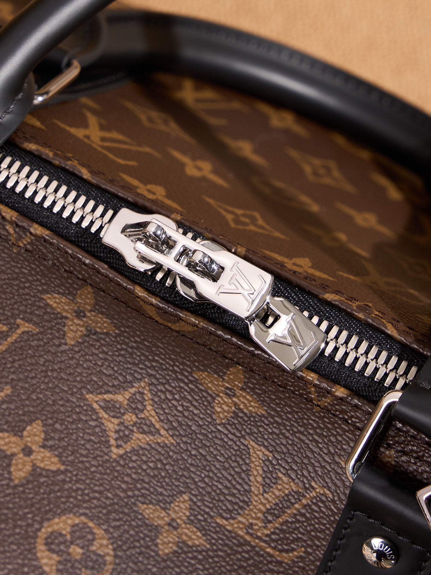 Zip pull and silver-toned metal trim on monogram duffel bag