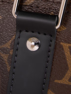 Black leather luggage tag with LV emblem on monogram duffel bag strap