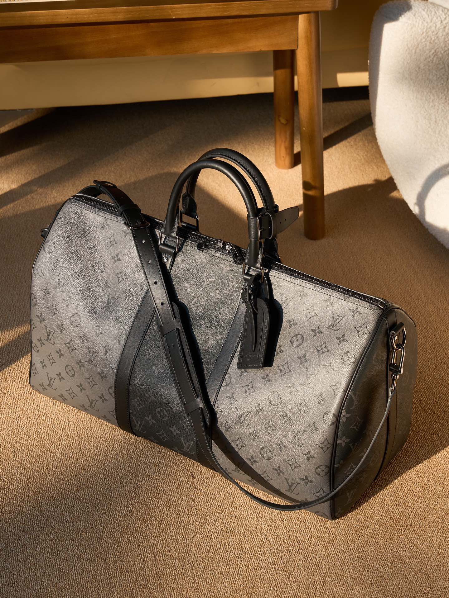 Men's Louis Vuitton duffel bag with monogram canvas and black leather handles