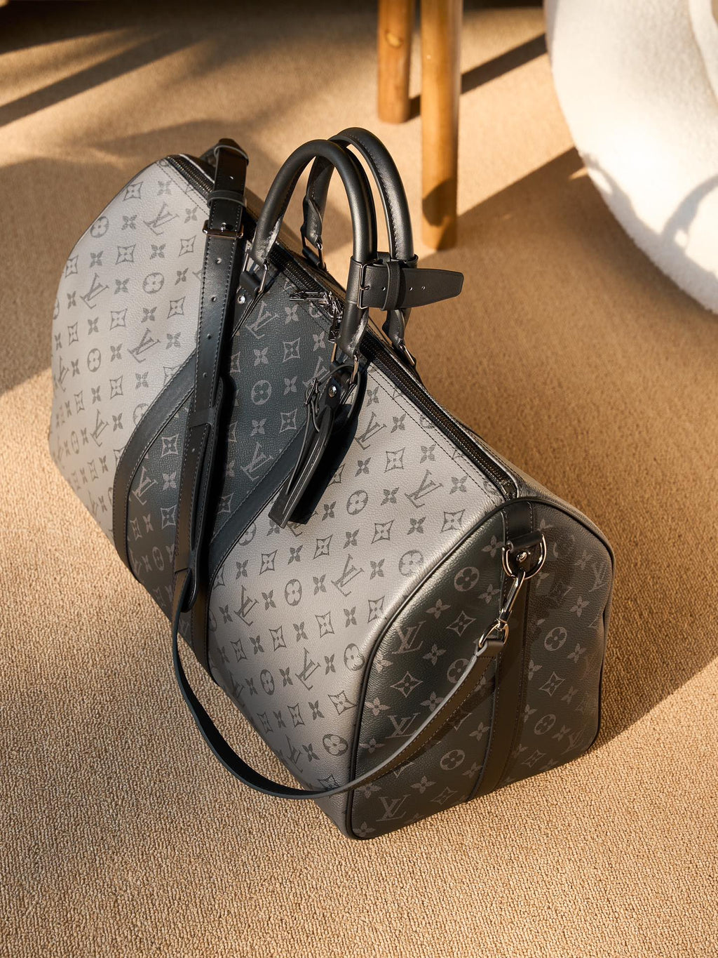 Men's Louis Vuitton duffel bag with monogram canvas, black leather trim and shoulder strap