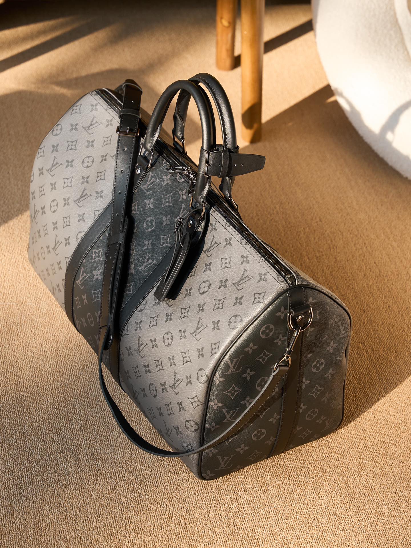 Men's Louis Vuitton duffel bag with monogram canvas, black leather trim and shoulder strap