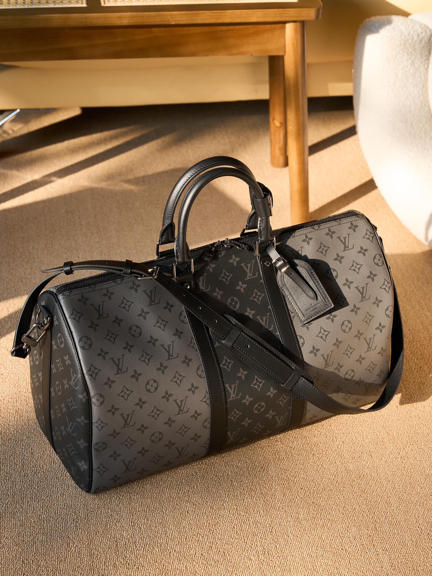 Men's Louis Vuitton duffel bag with monogram canvas and black leather top handles