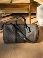 Men's Louis Vuitton duffel bag with monogram canvas, black leather strap and hardware