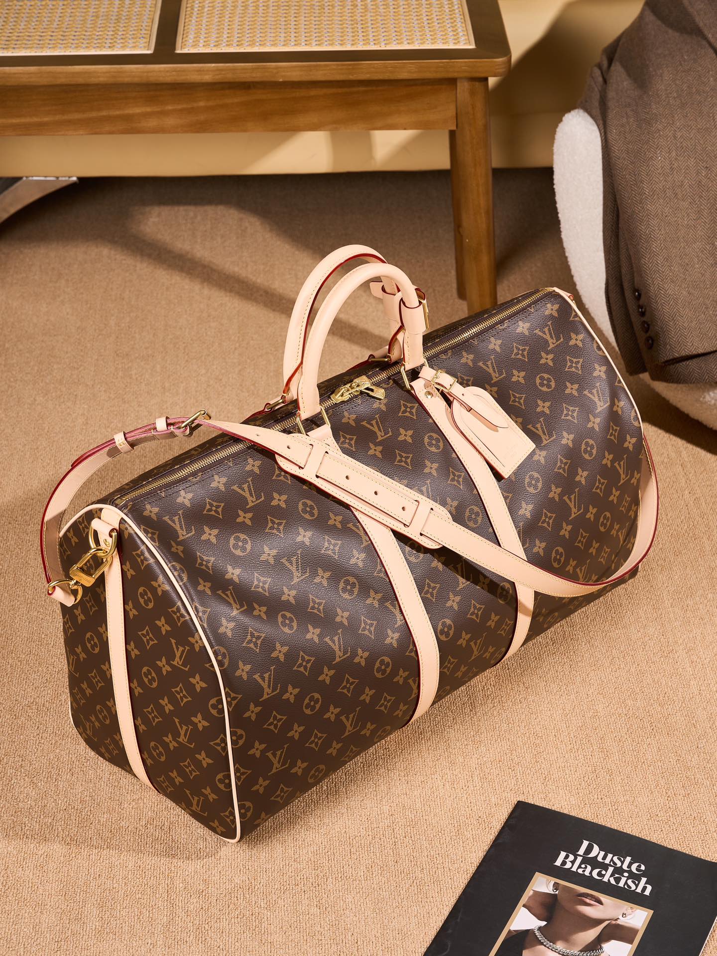 Monogram duffel bag with tan handles and side profile, gold zipper ends