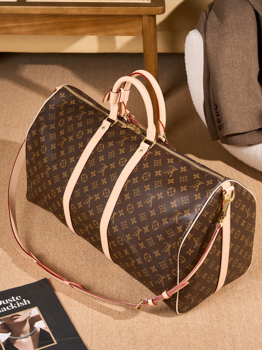 Monogram duffel bag with tan top handles, crossbody strap, and front pocket