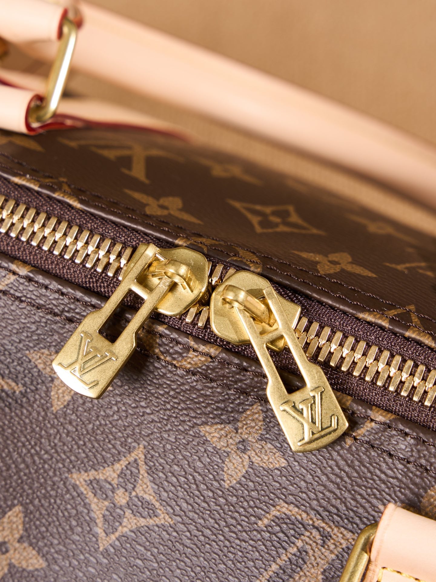 Monogram duffel bag zipper with gold hardware and leather pull tab