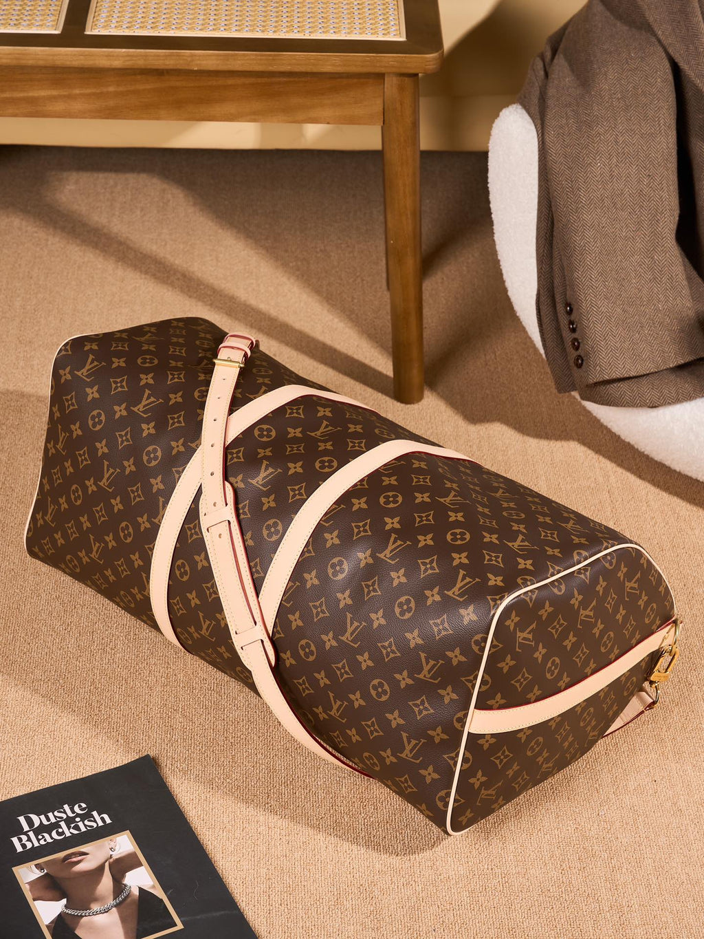 Monogram duffel bag with tan shoulder strap and rounded end seams