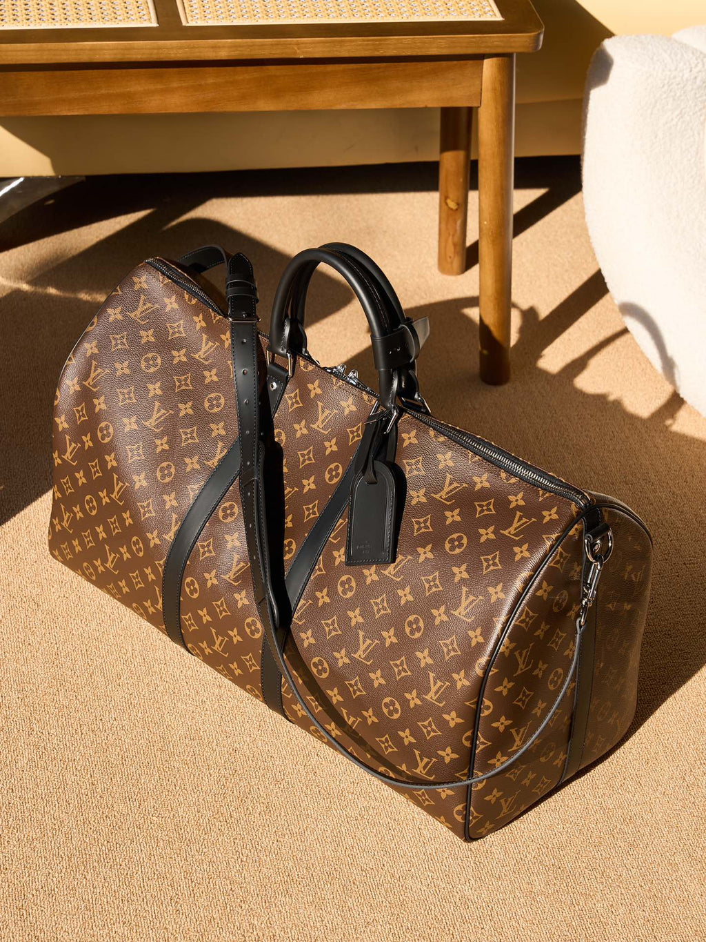 Louis Vuitton monogram duffel bag with black leather handles and shoulder strap