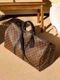 Louis Vuitton monogram duffel bag with black leather handles and shoulder strap