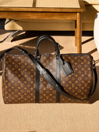 Monogram duffel bag with black crossbody strap and top handles, front view